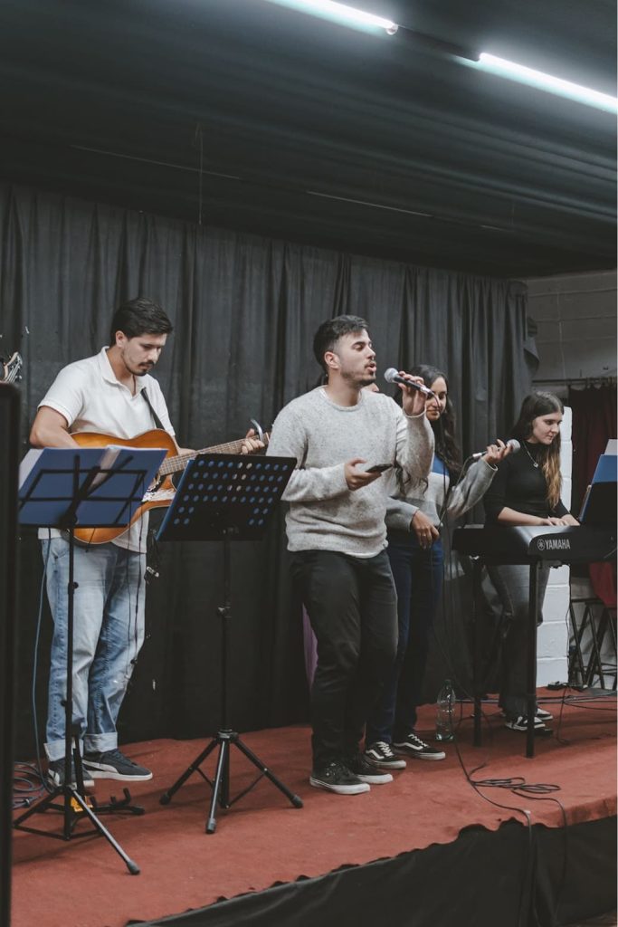 Imagen de jóvenes en la alabanza cantando y tocando instrumentos