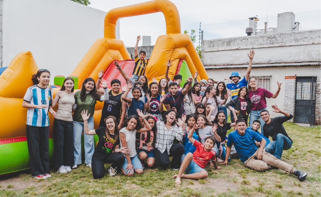 Foto del equipo y de los adolescentes, Prado's, con un castillo inflable de fondo